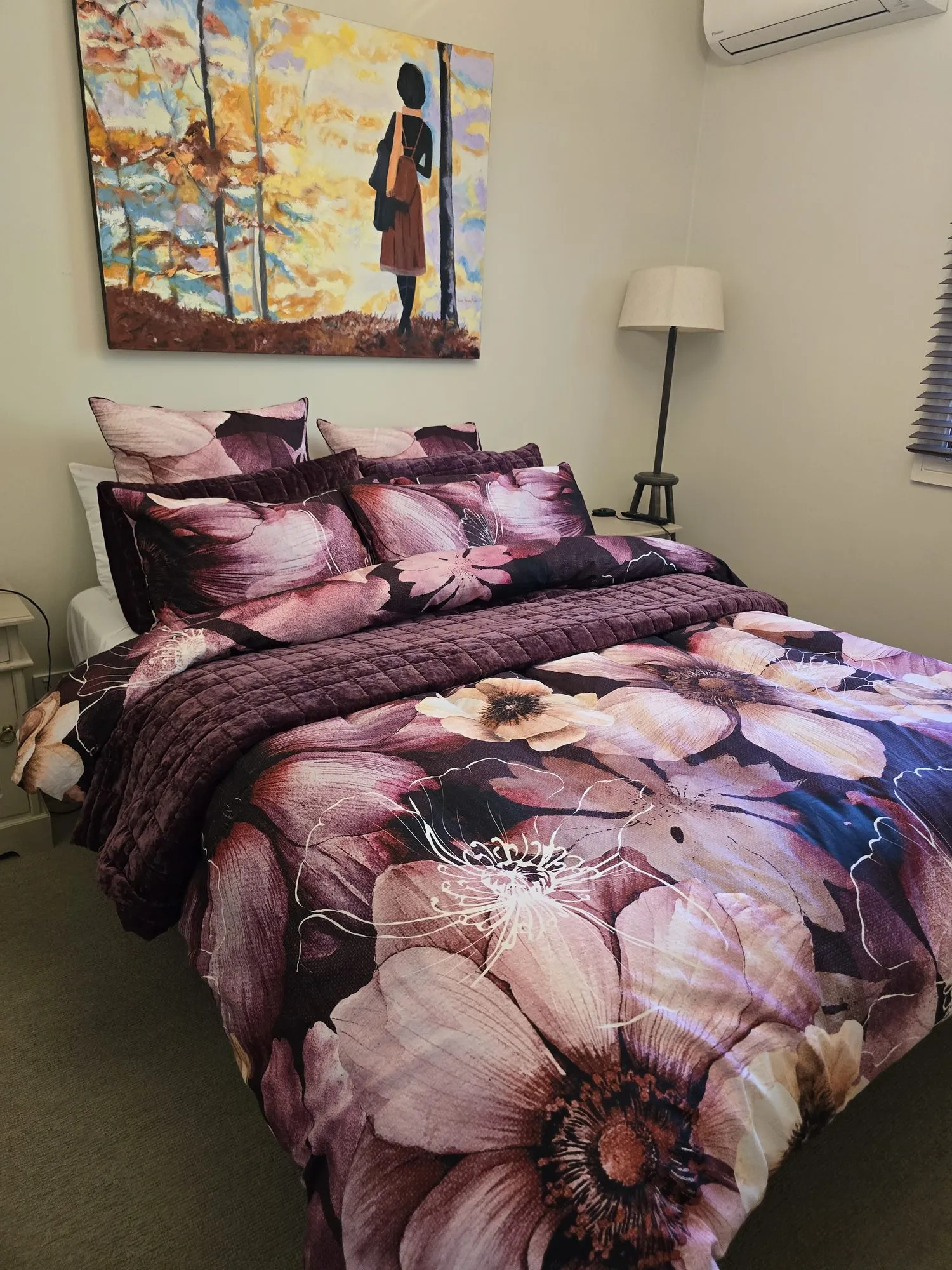 Etona Suite bedroom with olive velvet quilt beneath a large painted canvas