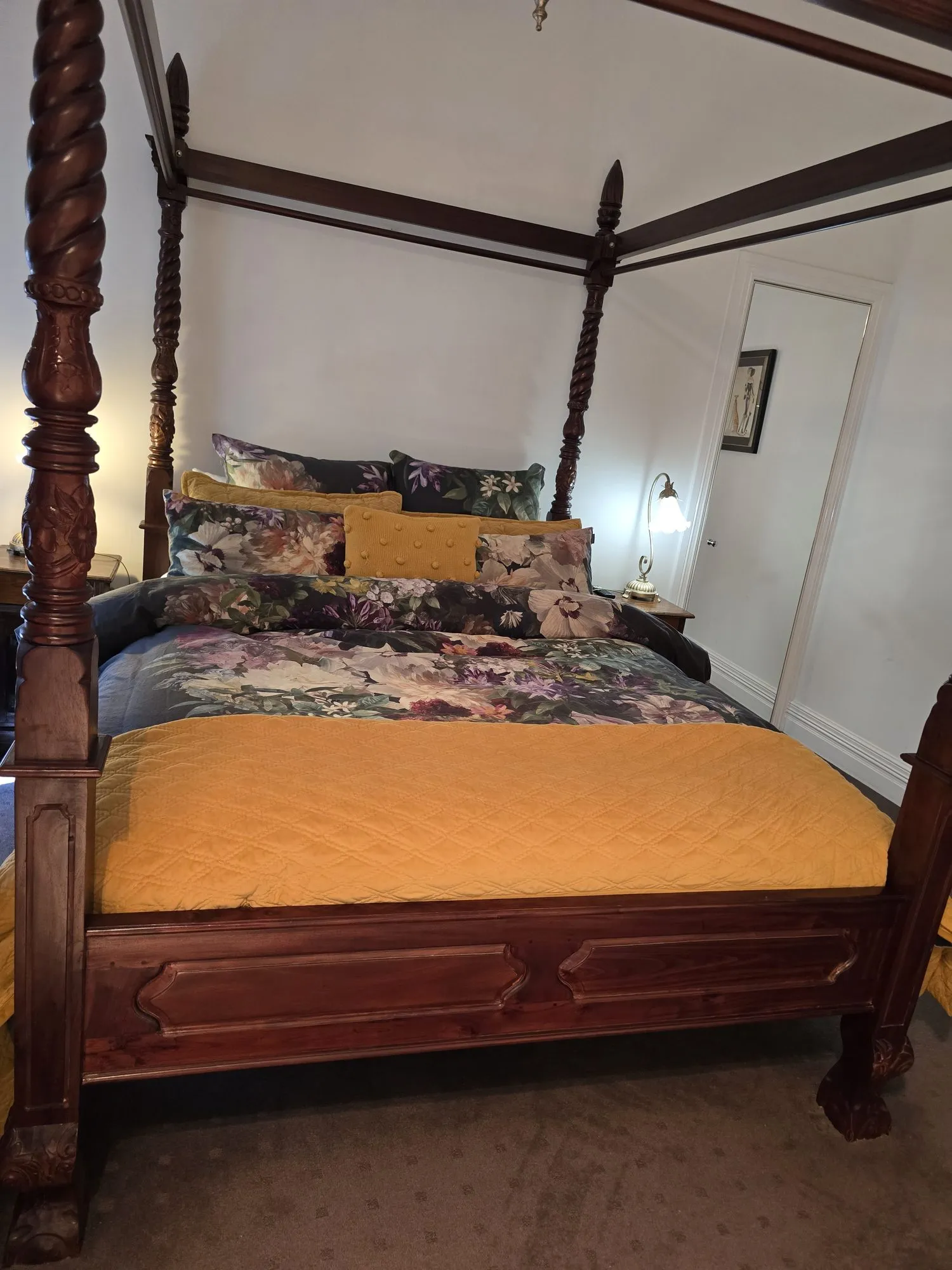 Adelaide Suite four-poster queen bed with a floral quilt and gold coverlet
