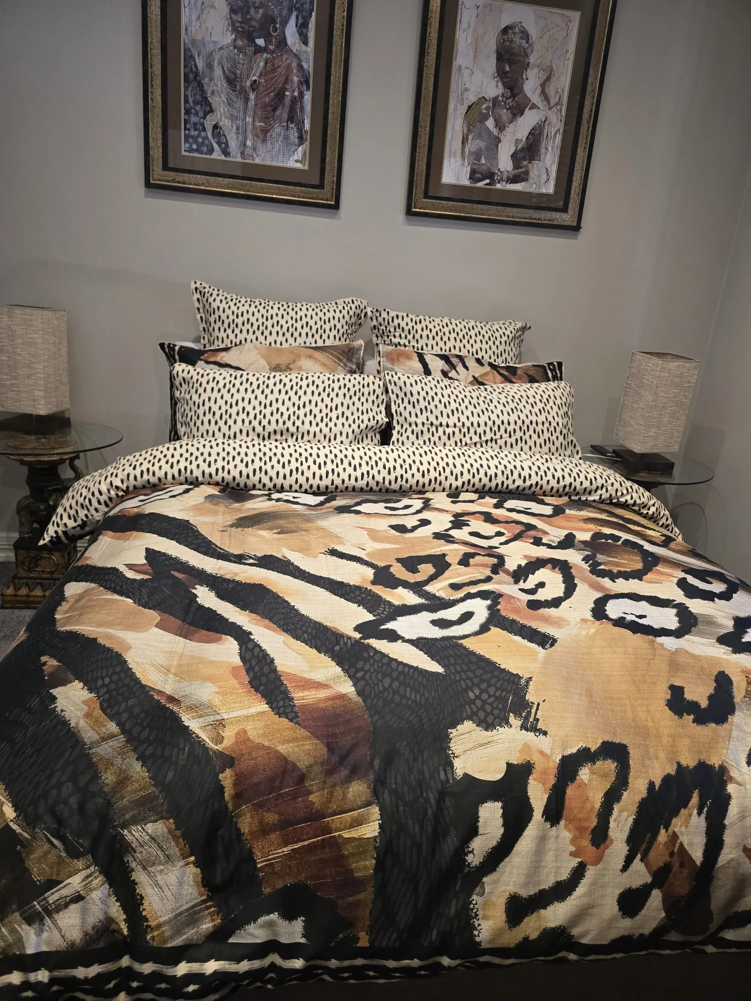 Emmylou queen bedroom with an animal-print quilt beneath two framed African portraits